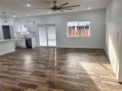 Unfurnished living room featuring sink, dark wood-