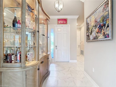 Entryway with crown molding and an inviting chandelier
