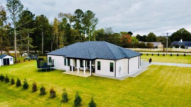 Back of property with a storage shed, a trampoline