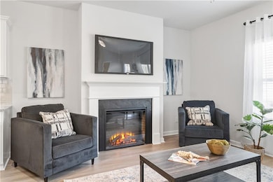 Living area with a glass covered fireplace and woo
