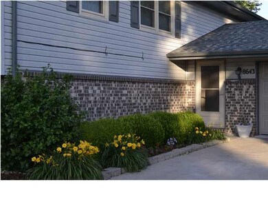 Entryway to home, mature and colorful landscaping.