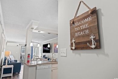Kitchen with open floor plan, a peninsula, white dishwasher, a textured ceiling, and pendant lighting