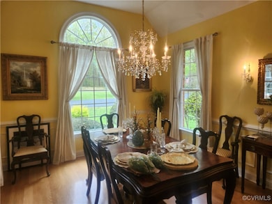 Dining area with lofted ceiling, a chandelier, and