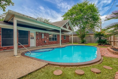 This backyard features a charming, covered patio a