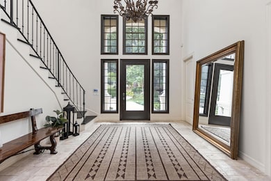 Entrance foyer with a towering ceiling, a chandel