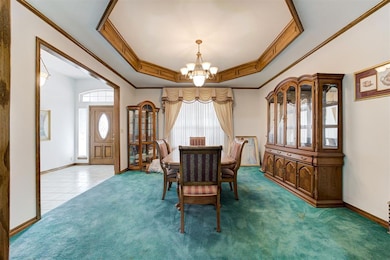 Carpeted dining room featuring a raised ceiling, c