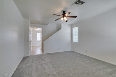 Spare room with light colored carpet, a ceiling fa
