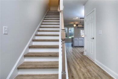 Stairs with wood finished floors and a ceiling fan
