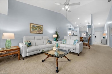 Living area with vaulted ceiling, a ceiling fan, a