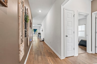 Hallway featuring wood-type flooring, plenty of natural light, and baseboards