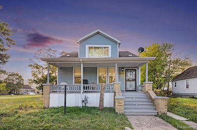View of front facade with a porch, a shingled roof, and a yard