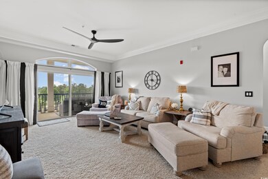 Carpeted living area featuring ceiling fan, visible vents, and crown molding