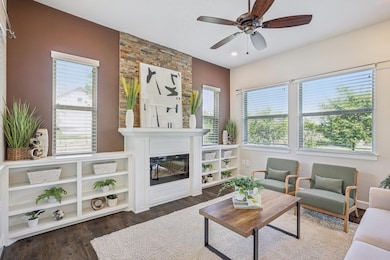 Living room featuring a ceiling fan, a fireplace,