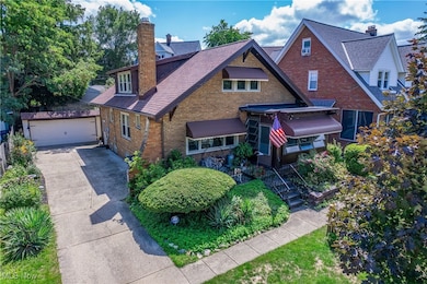 View of front of property with a garage and an outbuilding