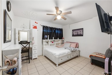 Bedroom featuring light tile patterned flooring and ceiling fan