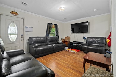 Living room featuring ornamental molding, wood fin
