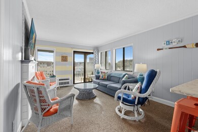 Carpeted living area with crown molding, a textured ceiling, heating unit, and a healthy amount of sunlight