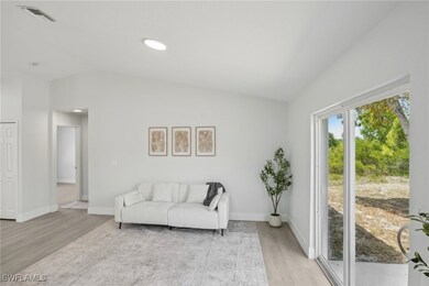 Living room featuring baseboards, vaulted ceiling,
