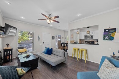 Living room featuring crown molding, ceiling fan,