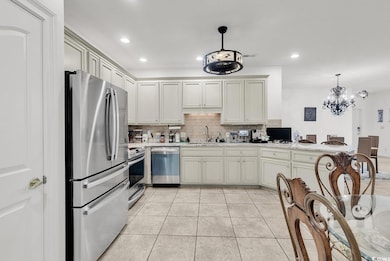 Kitchen featuring appliances with stainless steel finishes, backsplash, tile flooring, recessed lighting, and under cabinetry lighting