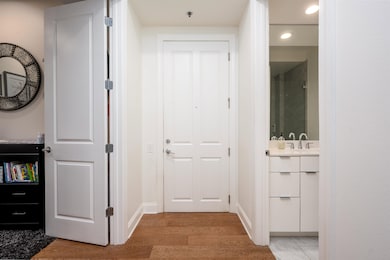 Hall with recessed lighting, a sink, light wood finished floors, and baseboards