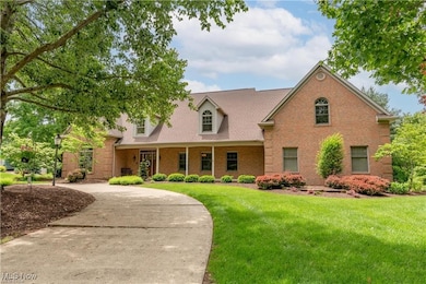 View of front facade featuring brick siding, a front yard, and covered porch