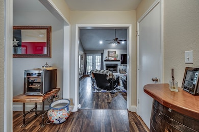 Hallway featuring wood finished floors, baseboards, a textured wall, and french doors