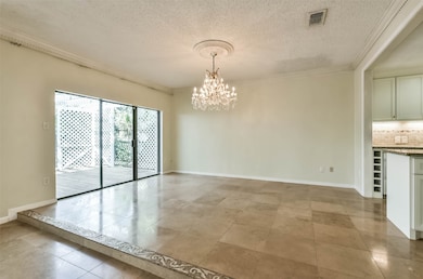 DINING ROOM-This light and bright room is located off the kitchen and den area and feature stone floors, dental molding and decorative lighting.