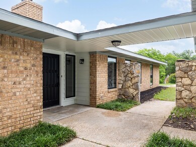 Property entrance with brick siding and a chimney