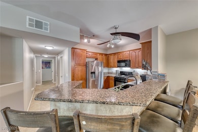 Kitchen with black appliances, a peninsula, a ceil