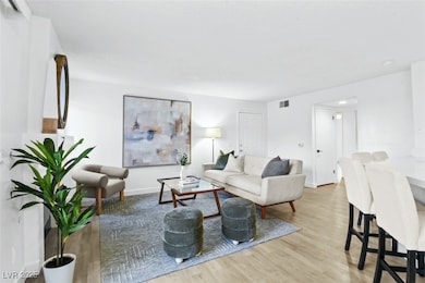 Living room featuring visible vents, baseboards, a