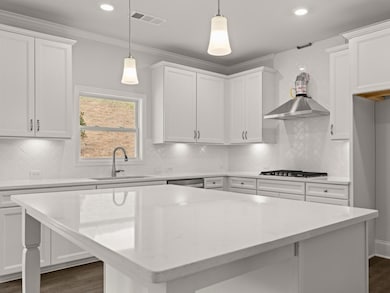 Westerly kitchen with white quartz countertops and white cabinets with crown molding