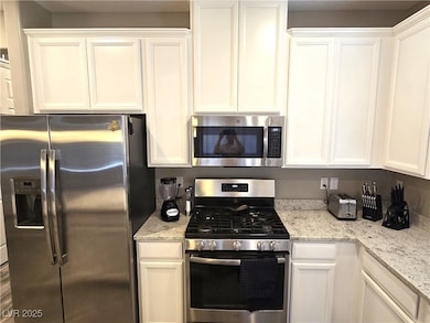 Kitchen with stainless steel appliances and white