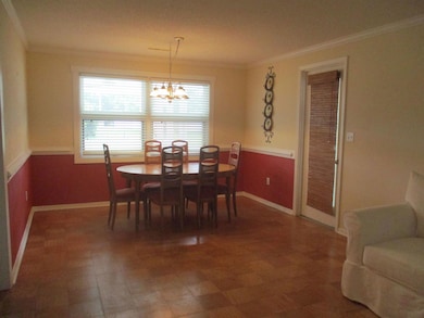 Dining room with a chandelier and ornamental molding