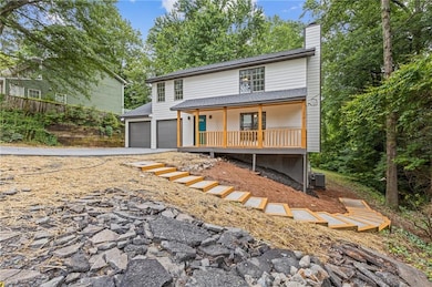 View of front of property featuring covered porch, a chimney, concrete driveway, central AC, and a shingled roof