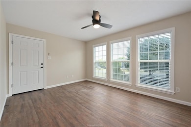 Spare room featuring ceiling fan and dark hardwood