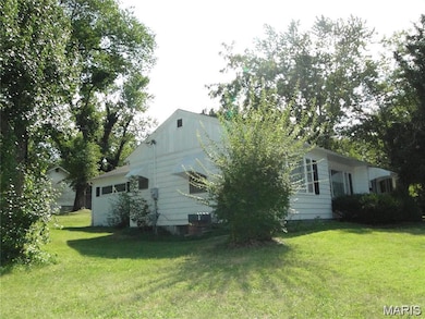 View of side of home with a yard