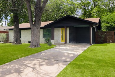 View of front of property with driveway and brick