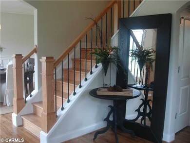 Foyer - hardwood floors, Oak stairs with wrough ir