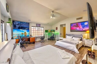 Bedroom with an office area, wood finished floors,