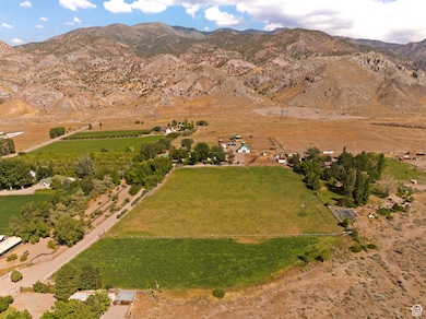 Aerial view of property and surrounding area with a mountainous background and rural landscape