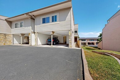 View of front of house with a carport and stone siding
