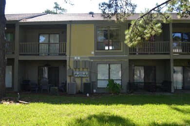 Back of house with a balcony, a yard, and central 