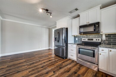 Kitchen featuring visible vents, dark wood finishe