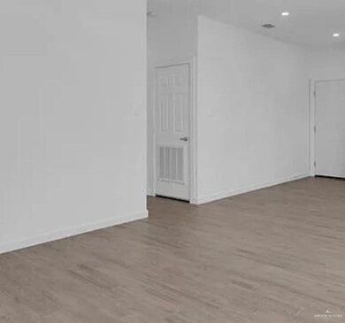 Unfurnished room wit. h light wood finished floors and baseboards