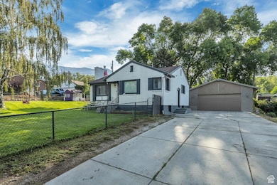 Bungalow featuring a detached garage, an outbuilding, a chimney, and a mountain view