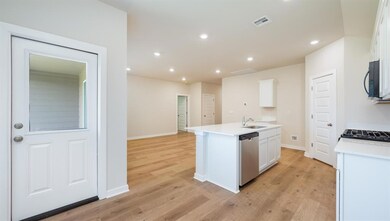 Kitchen featuring white cabinets, recessed lighting, a kitchen island with sink, light wood finished floors, and stainless steel dishwasher