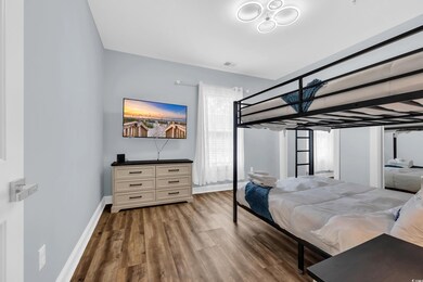 Bedroom with wood finished floors and baseboards