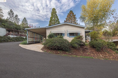 View of front of property with concrete driveway, a carport, and covered porch