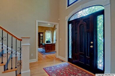 Elegant entry with staircase & gorgeous beveled glass over door installed by Lumpkin Stained Glass.